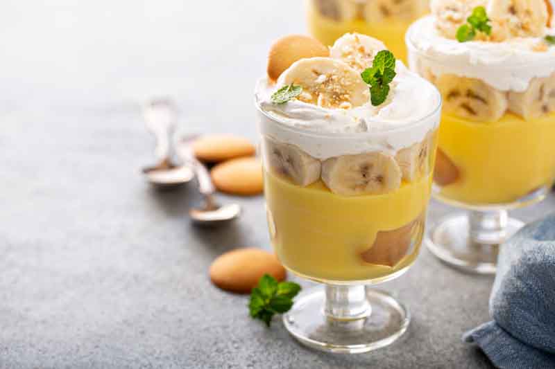 Banana pudding layered dessert with vanilla wafers in small glasses